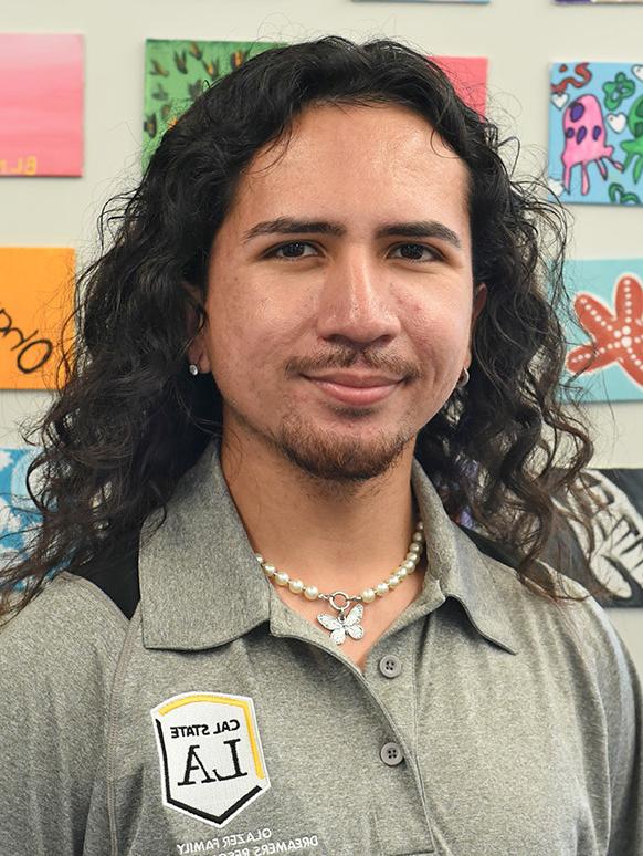 A person with long curly hair smiling