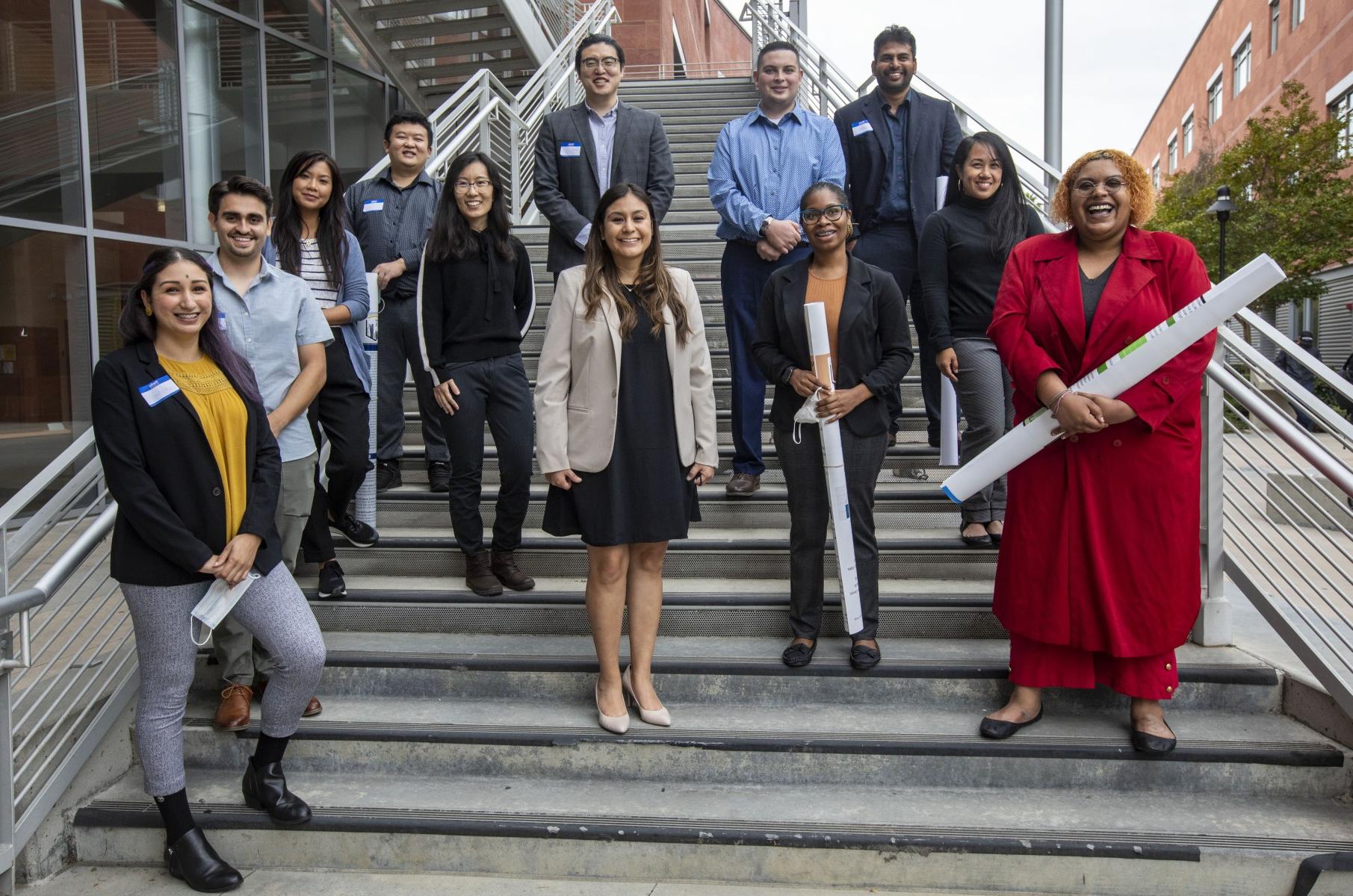 Group of students standing on a staircase smiling. 