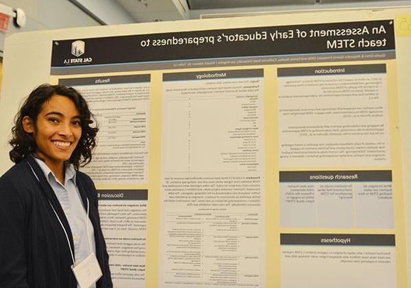 Student in front of research posterboard