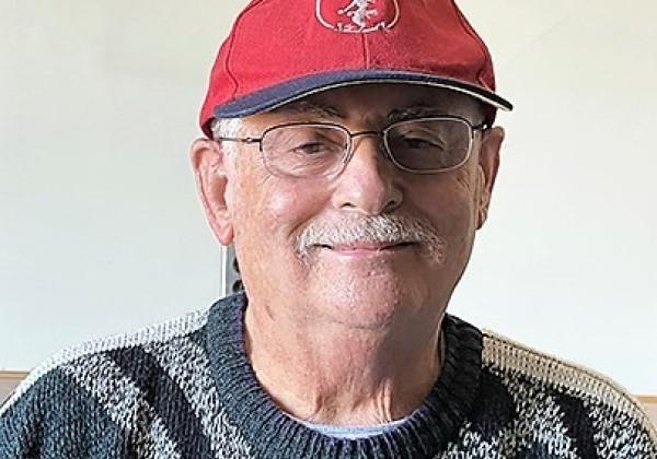 A man wearing a red cap smiling at the camera.