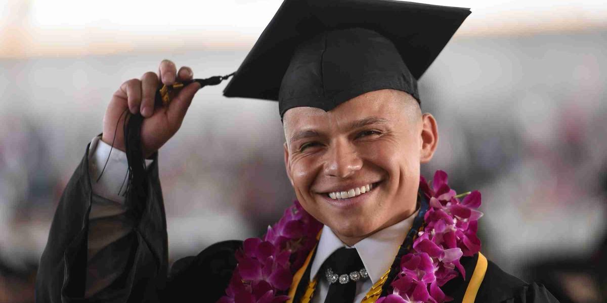 Male graduate wearing cap and gown.