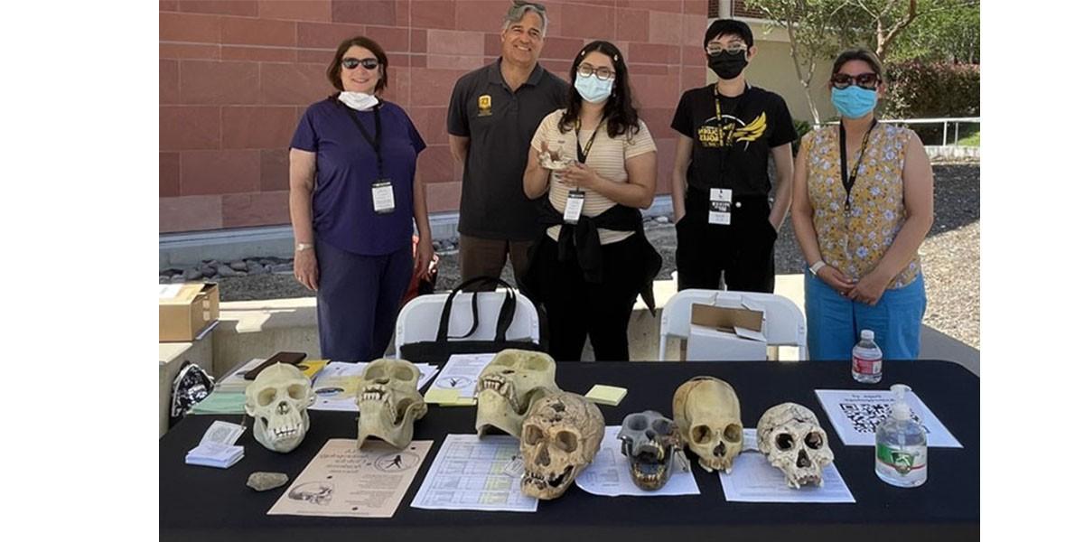 Two faculty members with three students at the Preview Day booth at Cal State LA