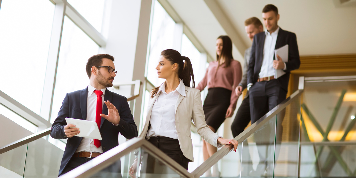 People in office descending staircase