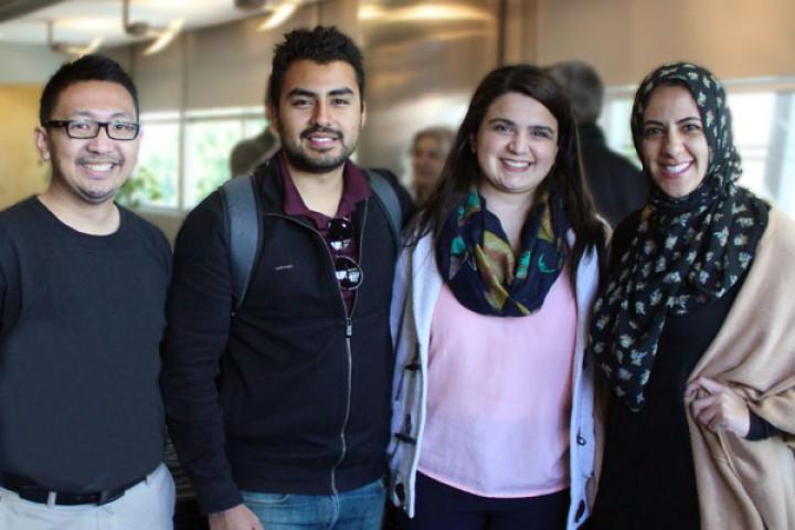 four students and graduates stand smiling