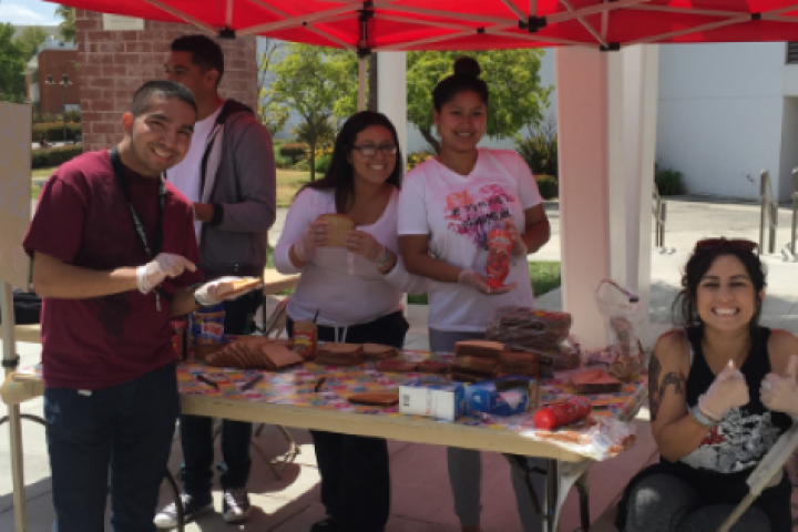 Students posing outside at a booth.