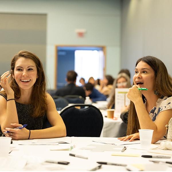 two professors sitting at a round table during a professional workshop