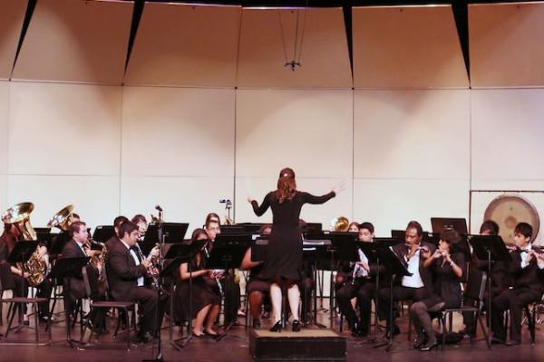 Image of a conductor in front of an orchestra of student musicians on stage